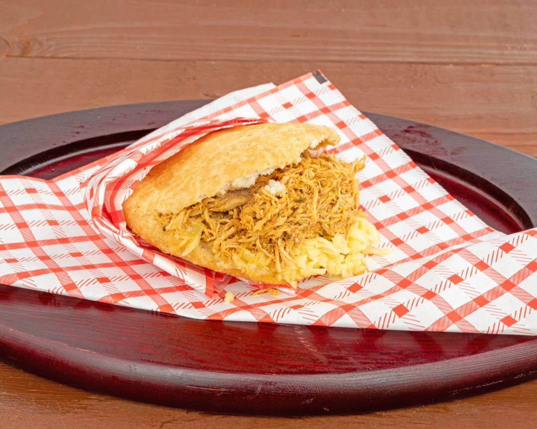 Arepa catira stuffed with shredded chicken and shredded yellow cheese