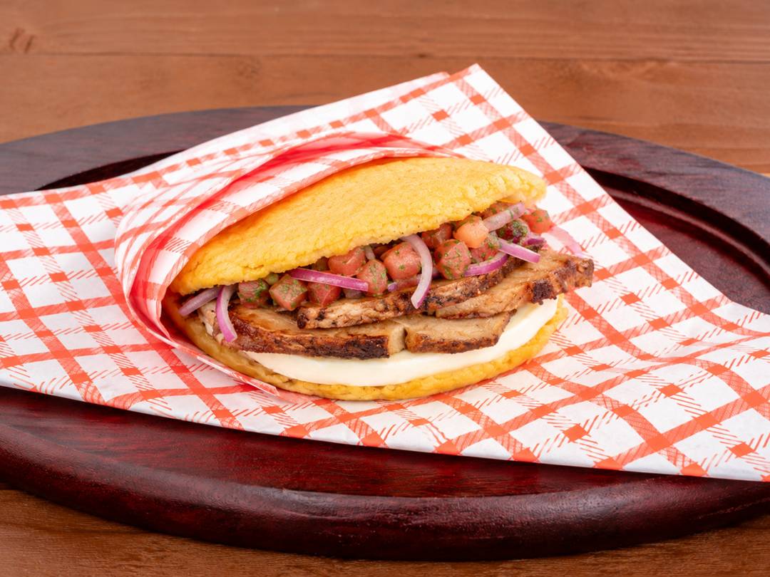 Arepa with sliced pernil, pico de gallo and cheese