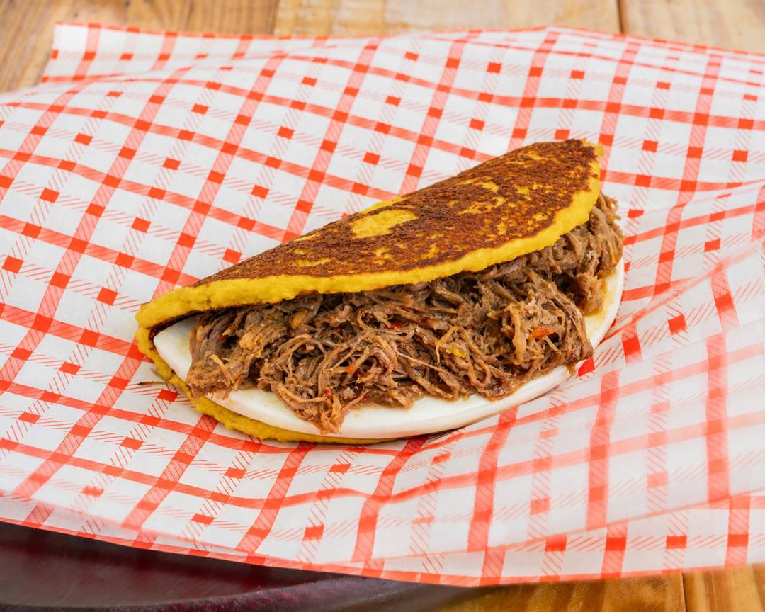 Cachapa stuffed with shredded beef carne mechada and queso de mano