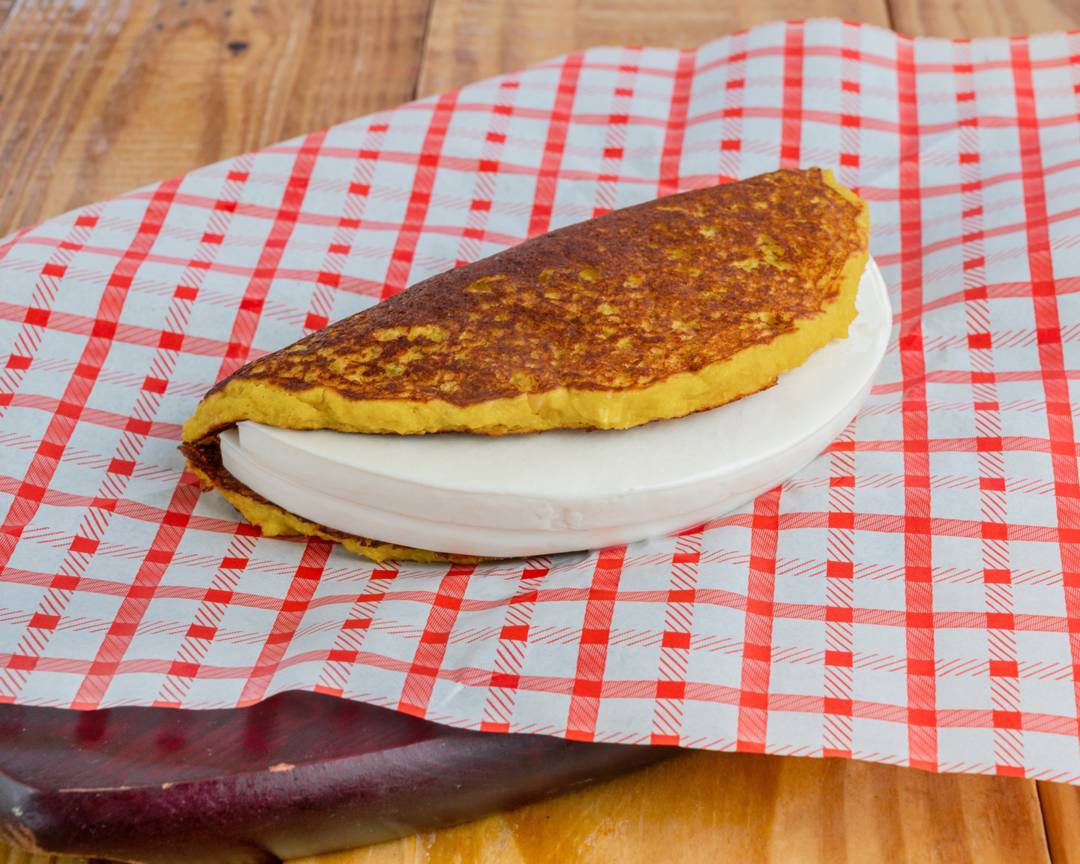 Cachapa completa folded over a thick slice of queso de mano
