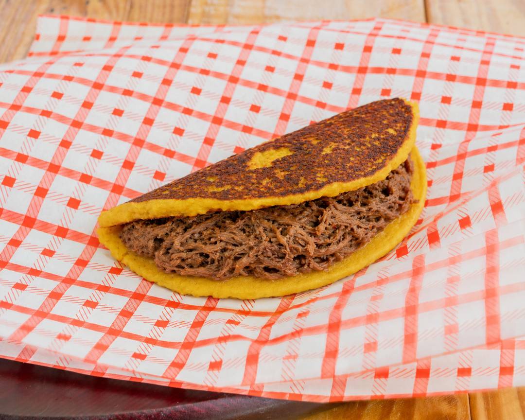 Cachapa overflowing with slow-cooked carne mechada